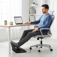 Man using foot massage pad at home office desk
